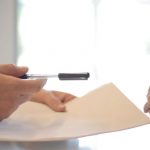 Privacy Policy - Crop businessman giving contract to woman to sign