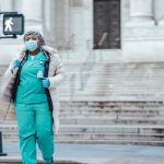 Healthcare Cross - Black physician in uniform crossing city road