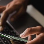 Software Selection - Crop faceless person using laptop and smartphone in darkness