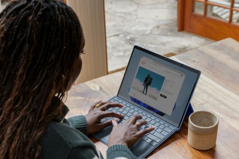 Blogging - a woman sitting at a table using a laptop computer