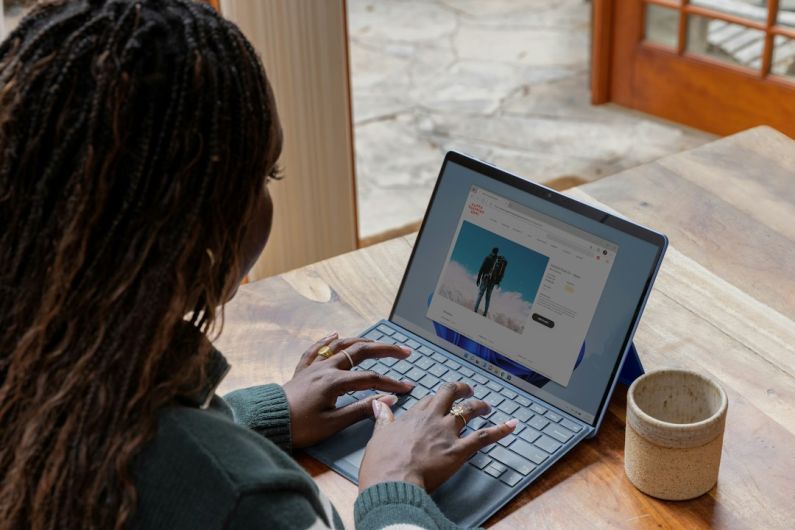 Blogging - a woman sitting at a table using a laptop computer