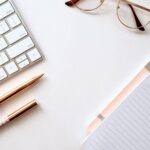 Blogging - pen near black lined paper and eyeglasses