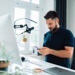 Influencer - man in blue polo shirt holding silver ipad