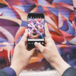 Influencer - person holding Android smartphone and taking a photo of abstract wall during daytime