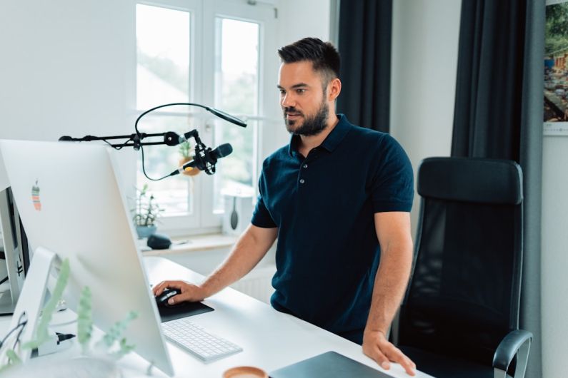 Influencer - man in blue crew neck t-shirt using macbook