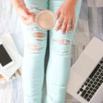 Influencers - person in blue denim jeans holding white ceramic mug