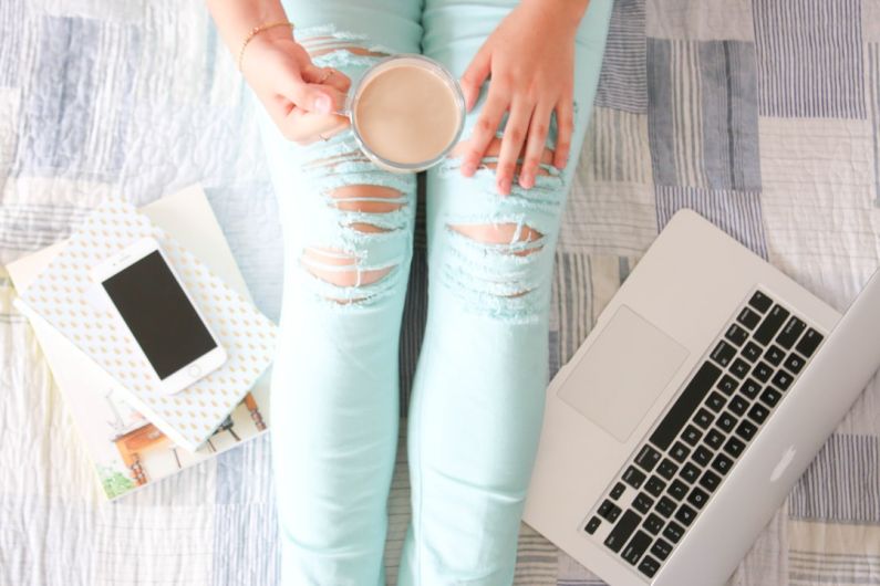 Influencers - person in blue denim jeans holding white ceramic mug