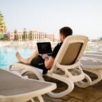 Influencers - man on sun lounger using laptop