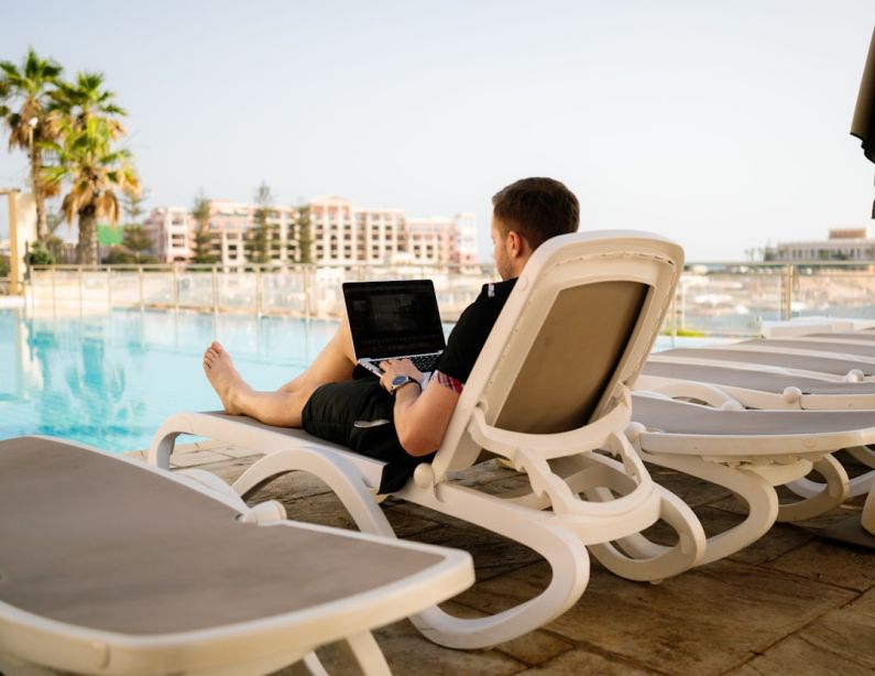Influencers - man on sun lounger using laptop