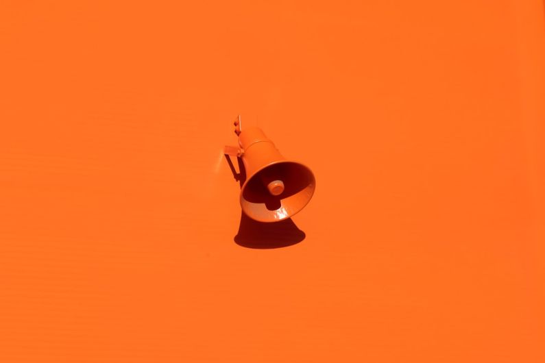 Brand - orange megaphone on orange wall