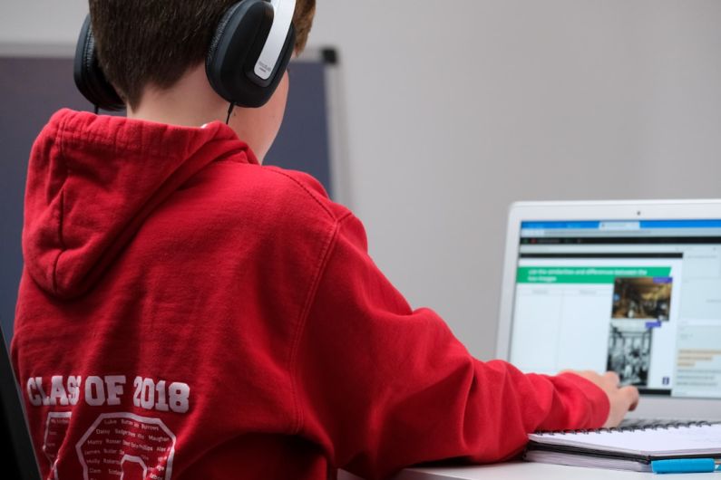Education Digital - boy in red hoodie wearing black headphones