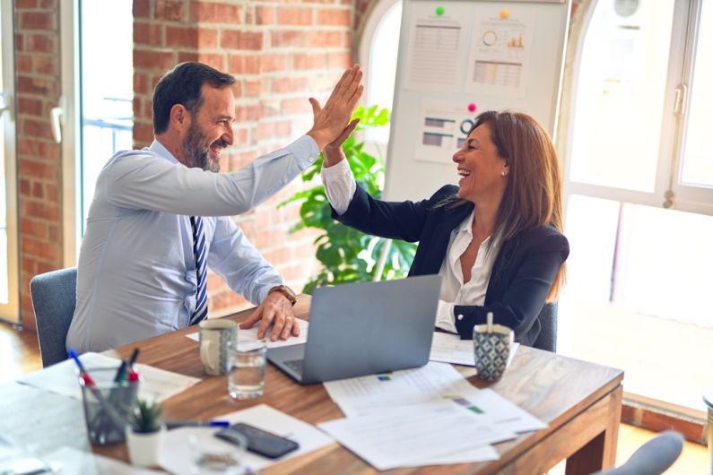Small Business - man in white dress shirt sitting beside woman in black long sleeve shirt